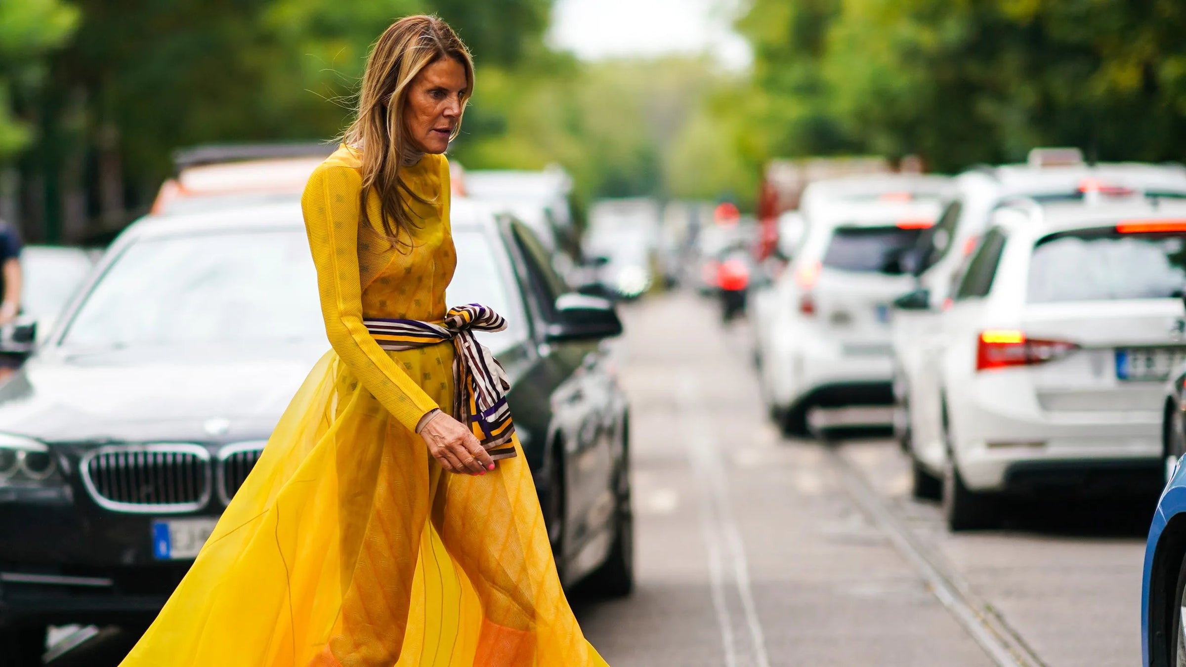 anna dello russo walking in long yellow dress