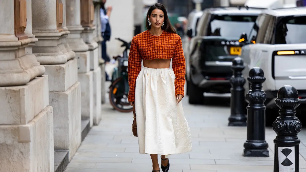 influencer in stomach baring top and white tulip skirt